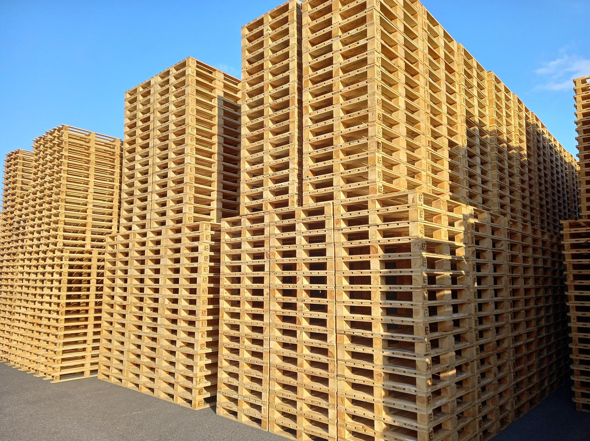 Grandes piles de stockage extérieur de palettes en bois neuves